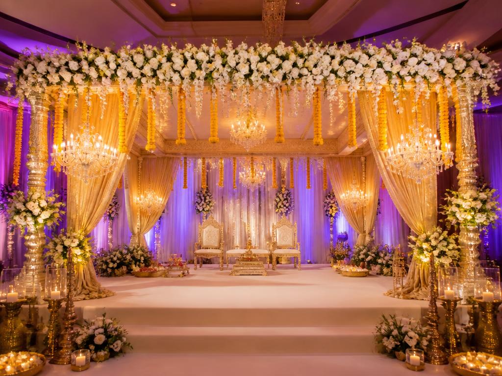 Luxury Indian wedding mandap decor with flowers and gold drapes